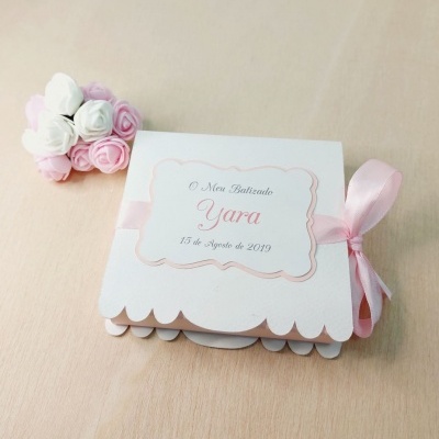 Convite de batizado com fita rosa e texto 'O Meu Batizado Yara 15 de Agosto de 2019'