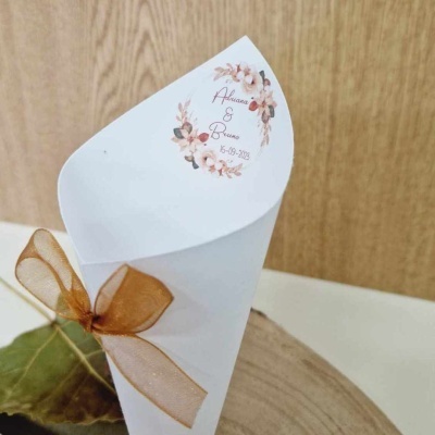 Cone branco com laço castanho e texto decorativo sobre base de madeira
