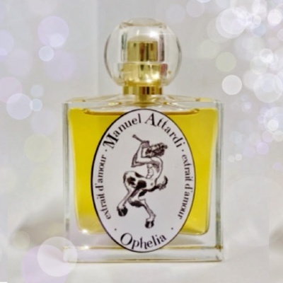 Três frascos quadrados de perfume com tampas douradas e etiquetas ovais brancas com texto preto, em fundo luminoso desfocado.