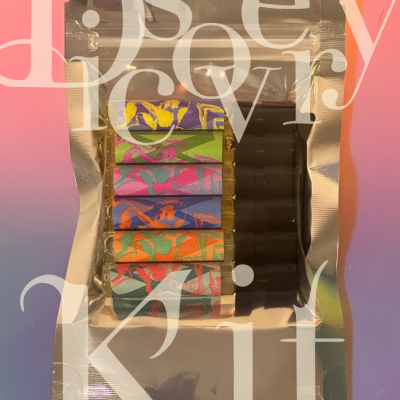 Set of colorful vaping cartridges in a silver resealable bag on gradient background