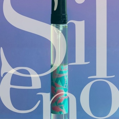 Clear spray bottle with black cap and green flamingo-patterned label