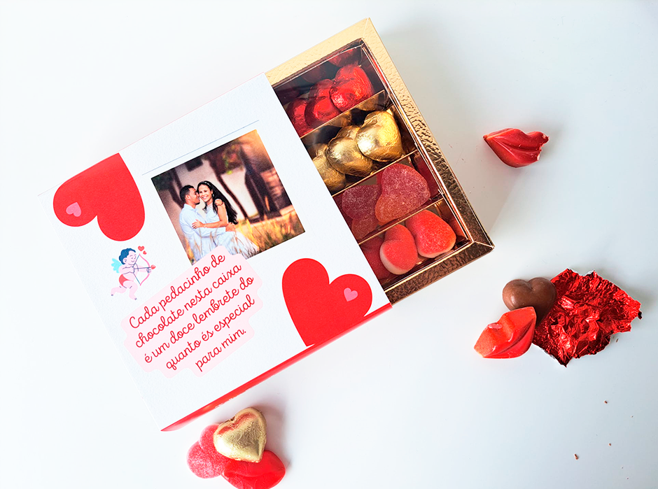 Caixa de chocolates variados em forma de coração e beijo, embalados e ao lado da caixa