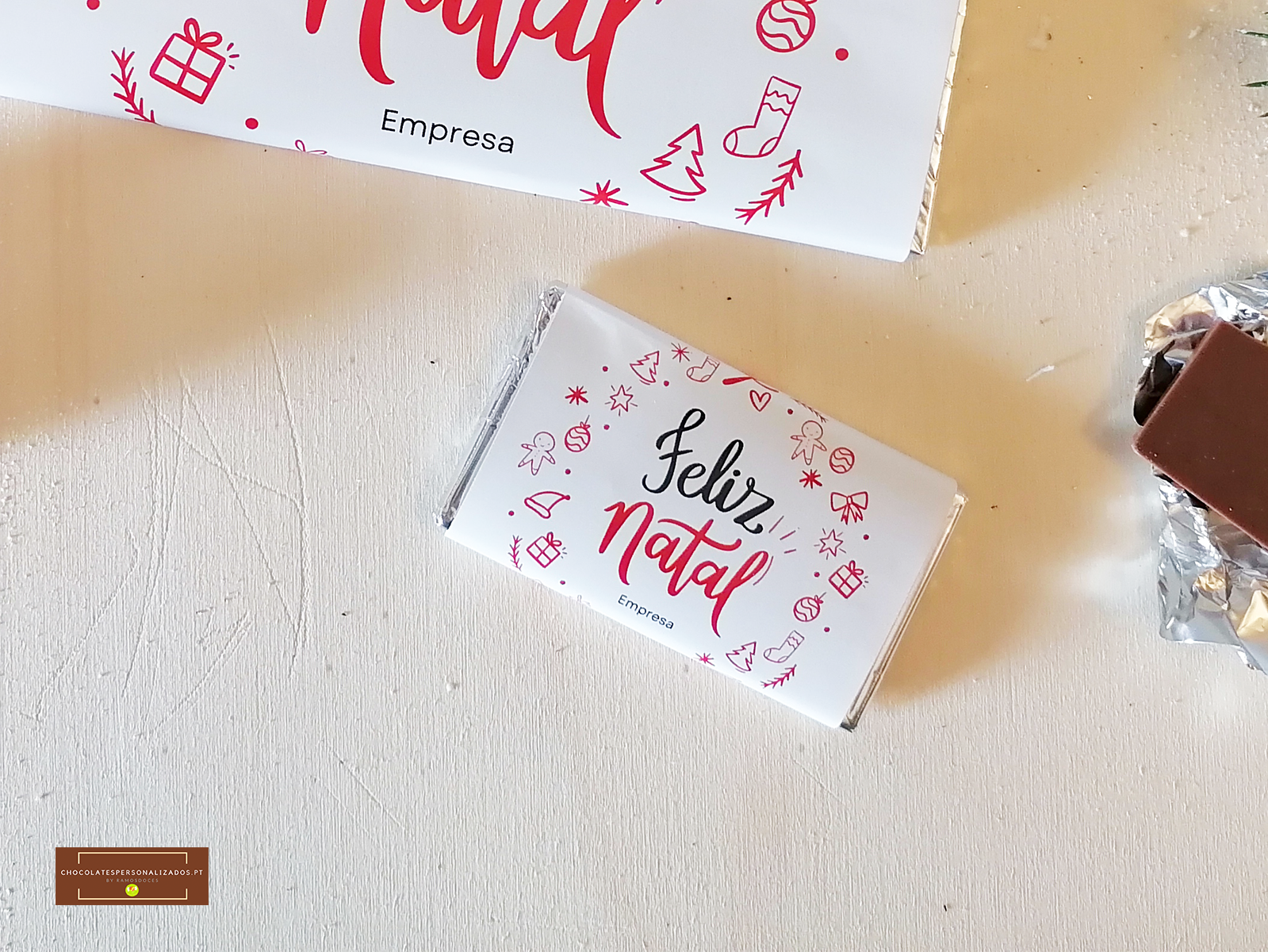 Barra de chocolate embrulhada com tema de Natal e texto FELIZ Natal.