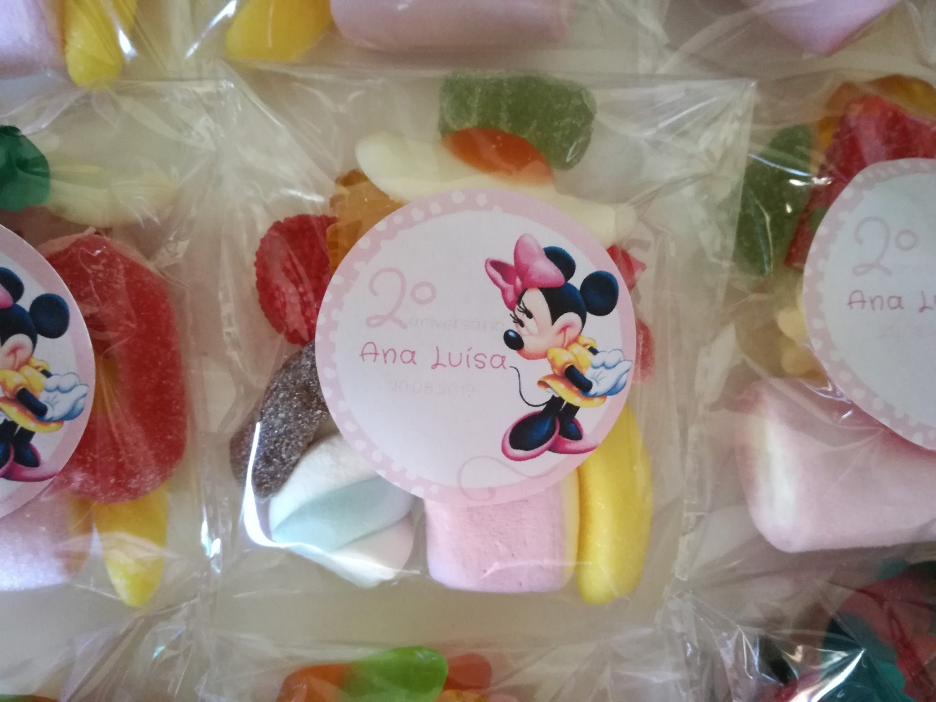 Pacote de doces coloridos com etiqueta da Minnie Mouse e texto '2º Ana Luisa'