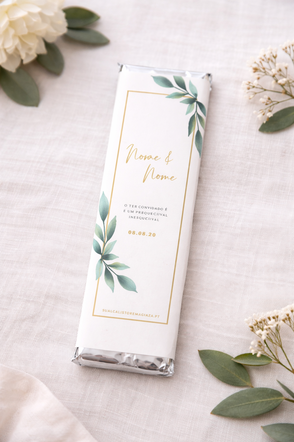 Chocolate com embalagem branca decorada com folhas verdes e texto dourado