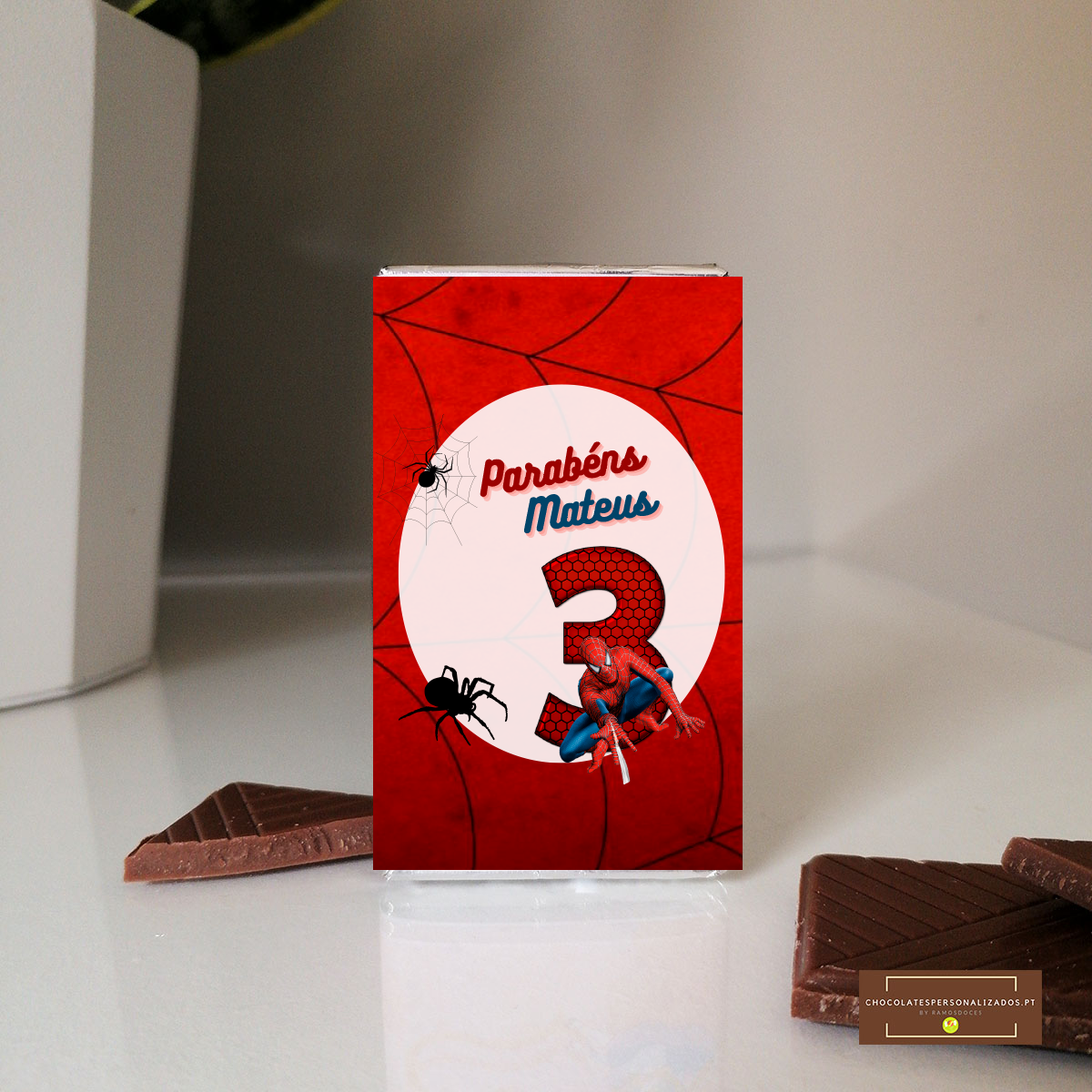 Embalagem de chocolate vermelha com tema Homem-Aranha e pedaços de chocolate ao leite