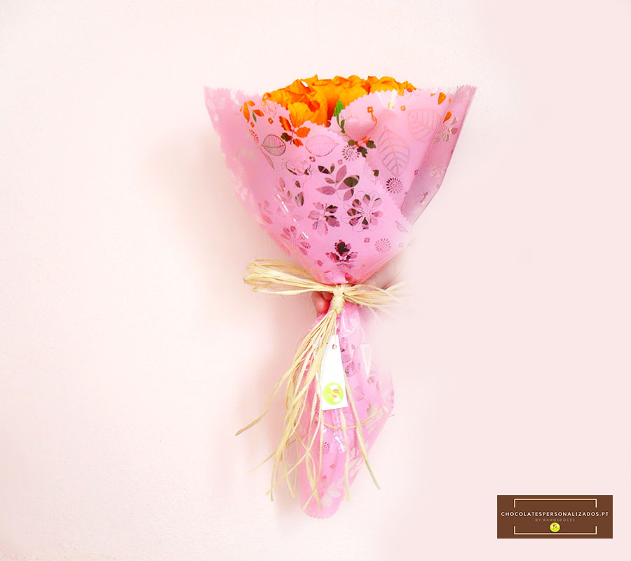 Ramo de flores amarelas em papel rosa com padrão floral e laço rústico