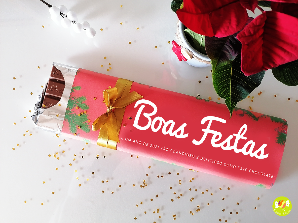Barra de chocolate embalada com papel vermelho com texto 'Boas Festas' e decoração natalícia