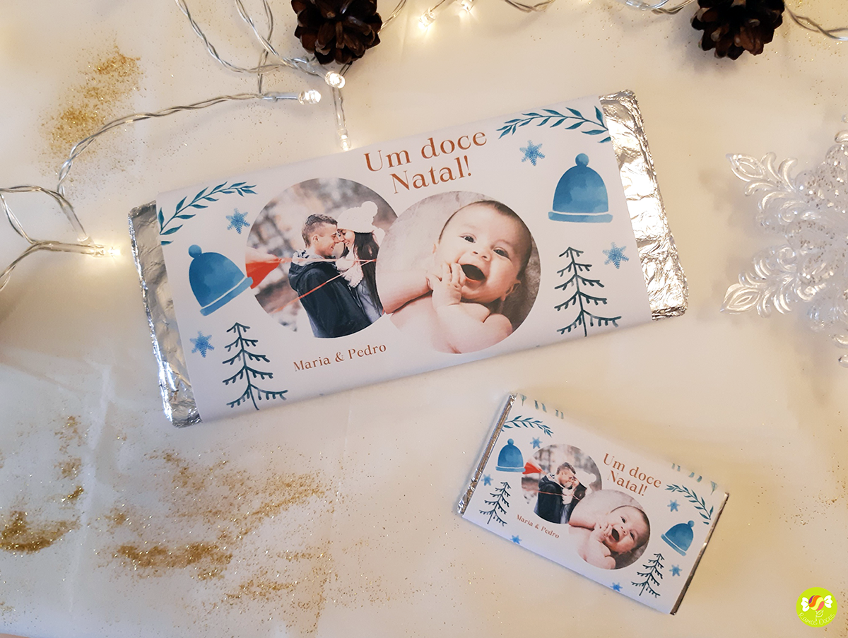 Barras de chocolate com rótulo personalizado de Natal com fotos e texto em embalagem de alumínio sobre mesa decorada.