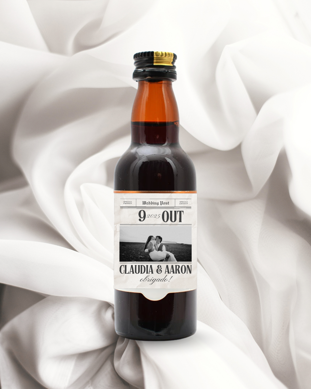 Garrafa pequena com etiqueta personalizada de casamento sobre tecido branco