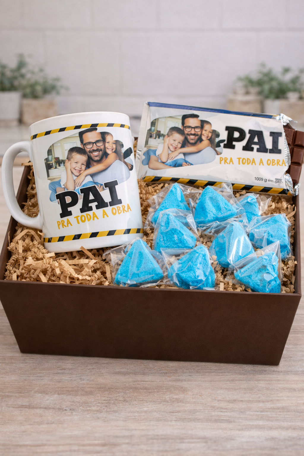 Caixa com copo, barra de chocolate e doces azuis para pai.