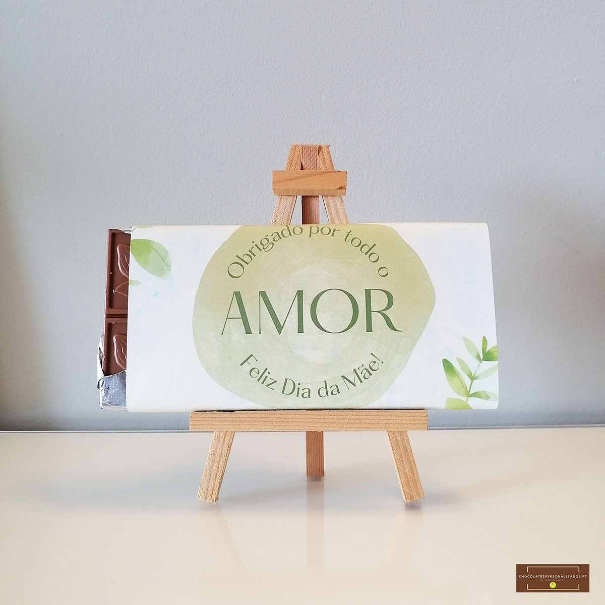 Barra de chocolate embrulhada com mensagem de Dia da Mãe posta num cavalete de madeira