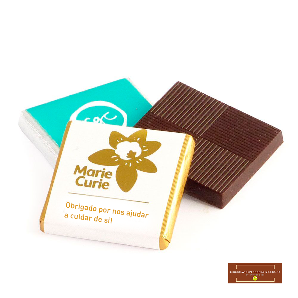 Três pedaços de chocolate quadrados com embalagens branca e azul e um pedaço sem embalagem