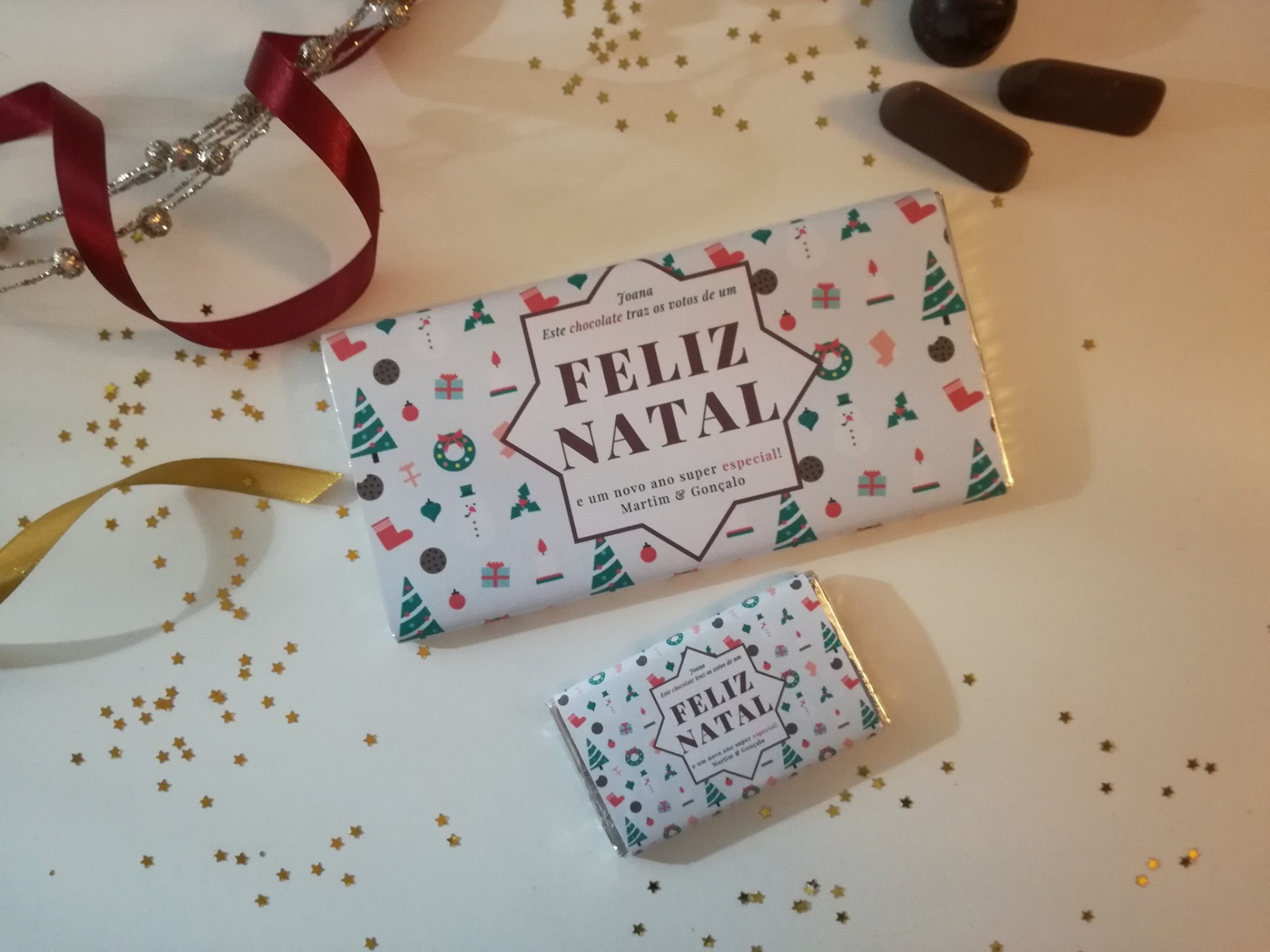 Dois chocolates embrulhados com tema de Natal e a frase FELIZ NATAL