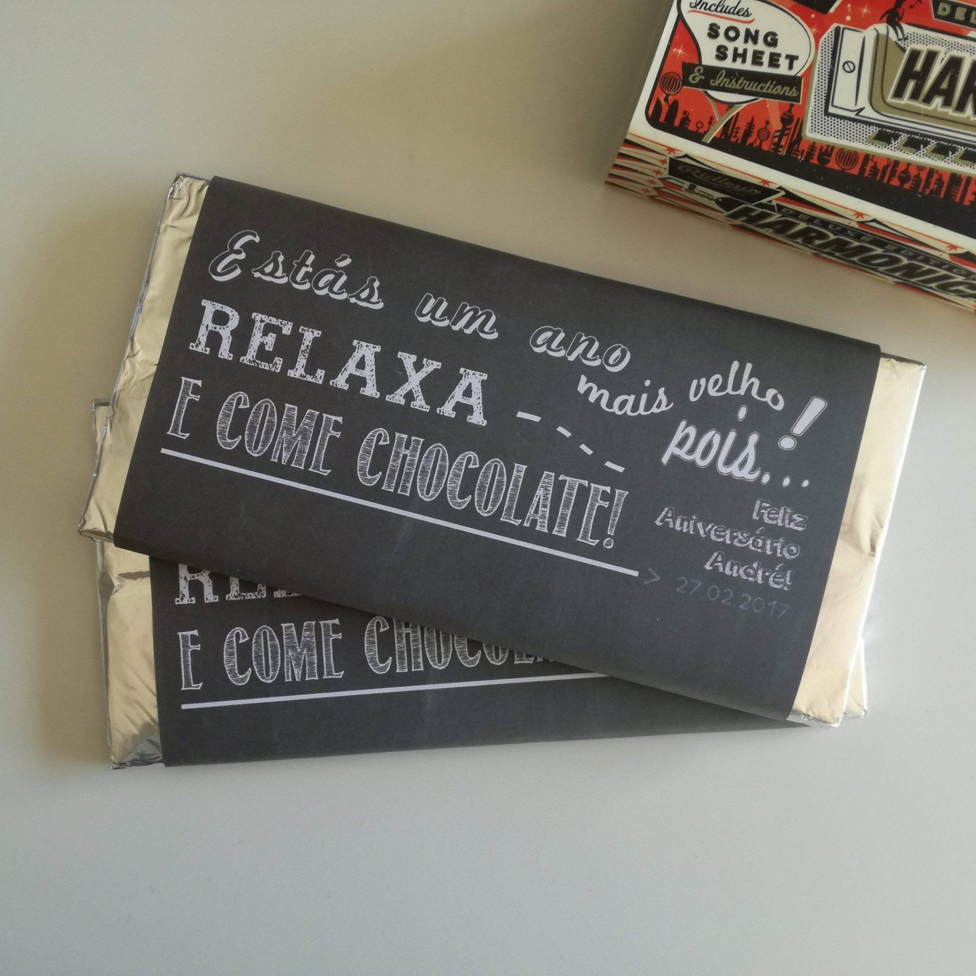 Dois tabletes de chocolate com embalagem preta e texto branco em português