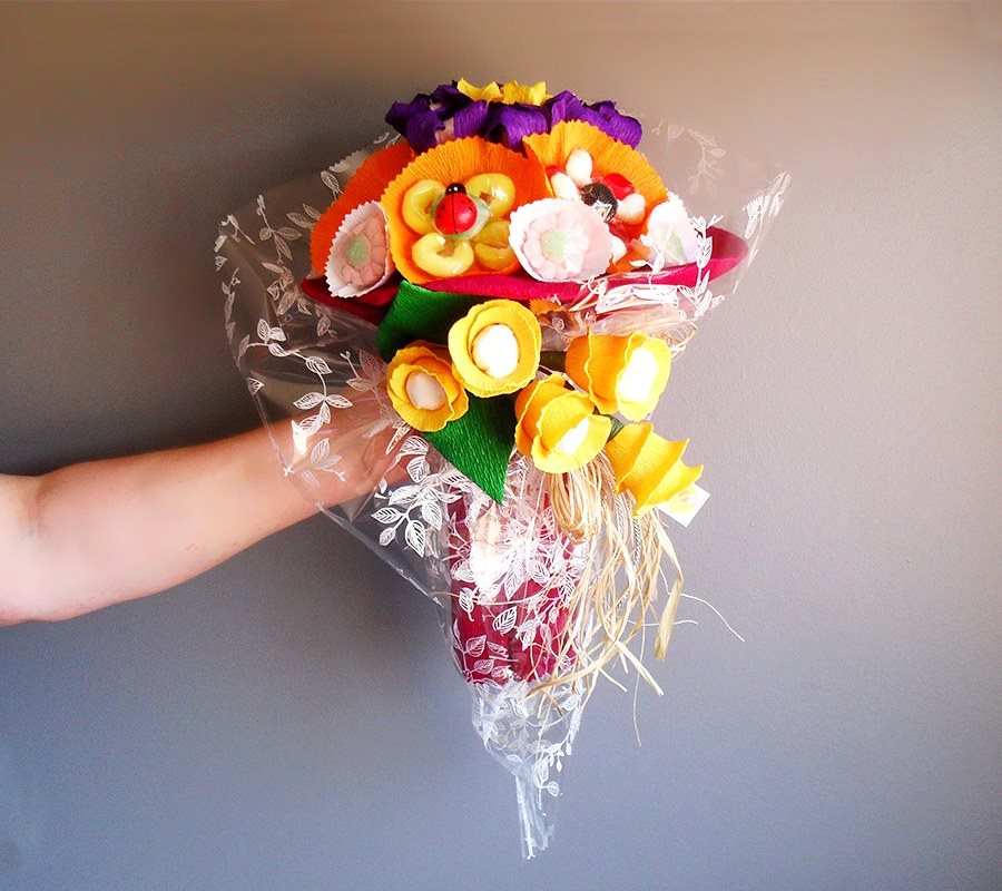 Buquê colorido de flores artificiais embalado em plástico transparent