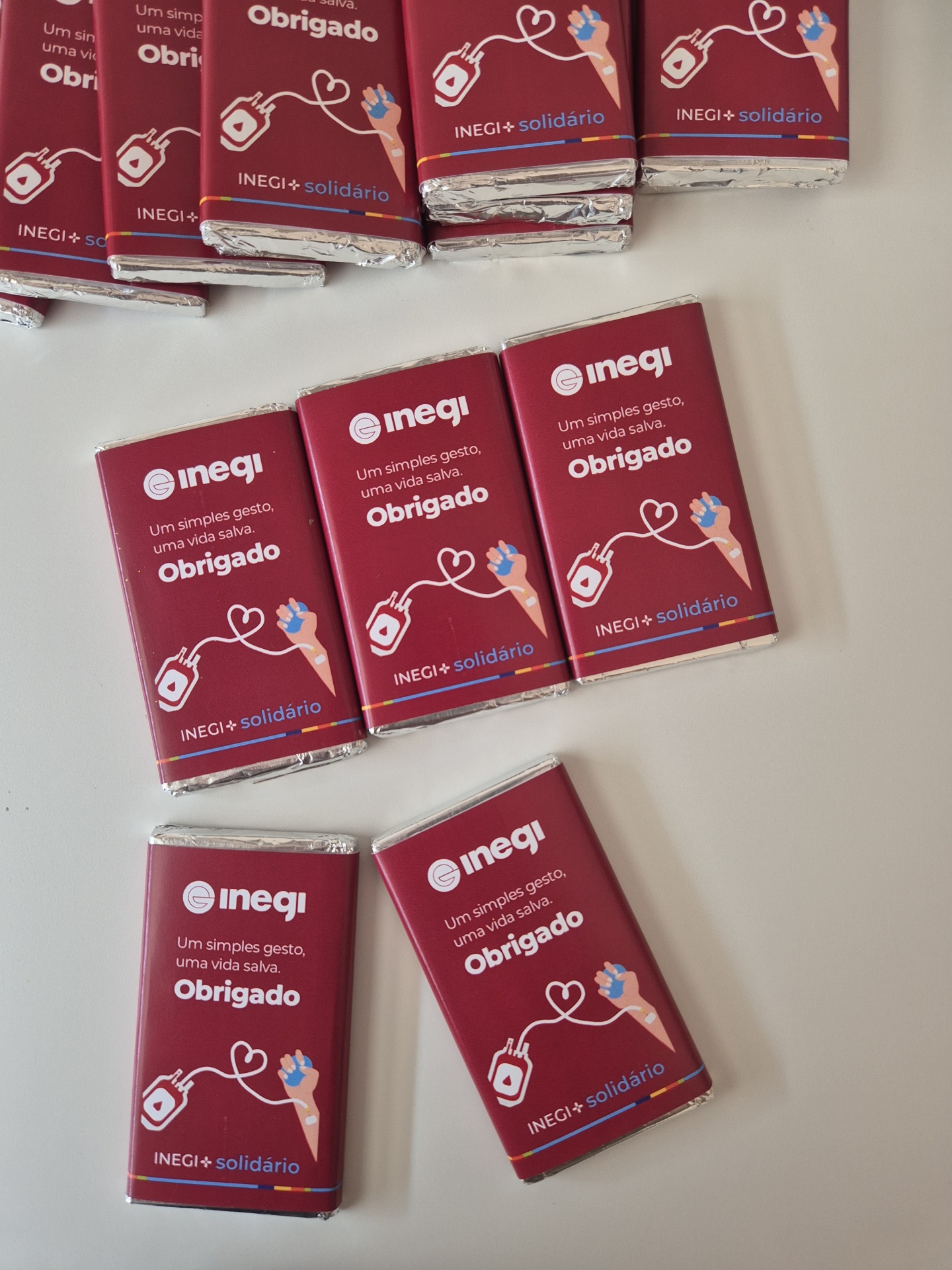 Pacotes de chocolate vermelhos com mensagem de agradecimento e campanha solidária