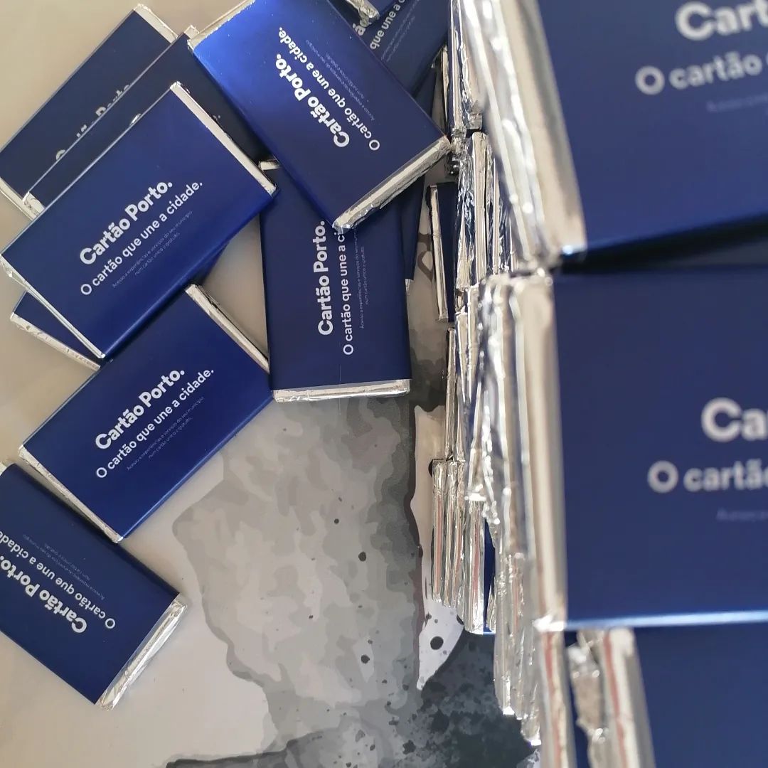 Barrinhas de chocolate com embalagem azul e texto branco sobre superfície metálica