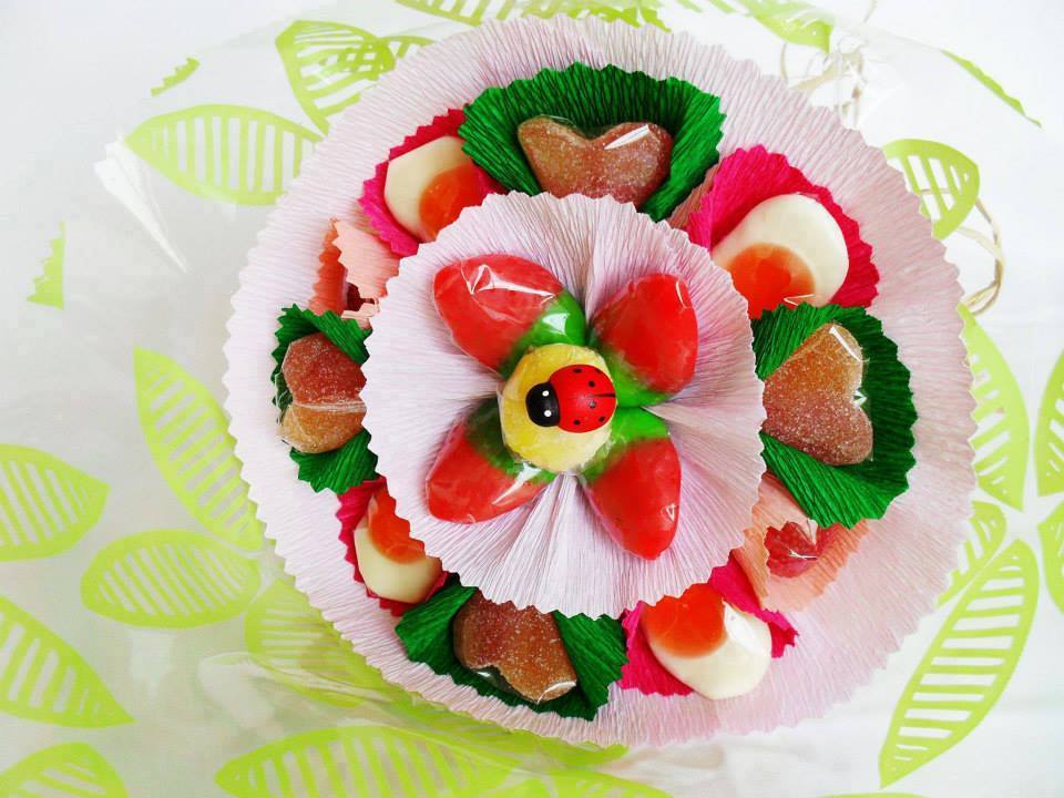 Arranjo de gomas coloridas em forminhas de papel com figura central de joaninha