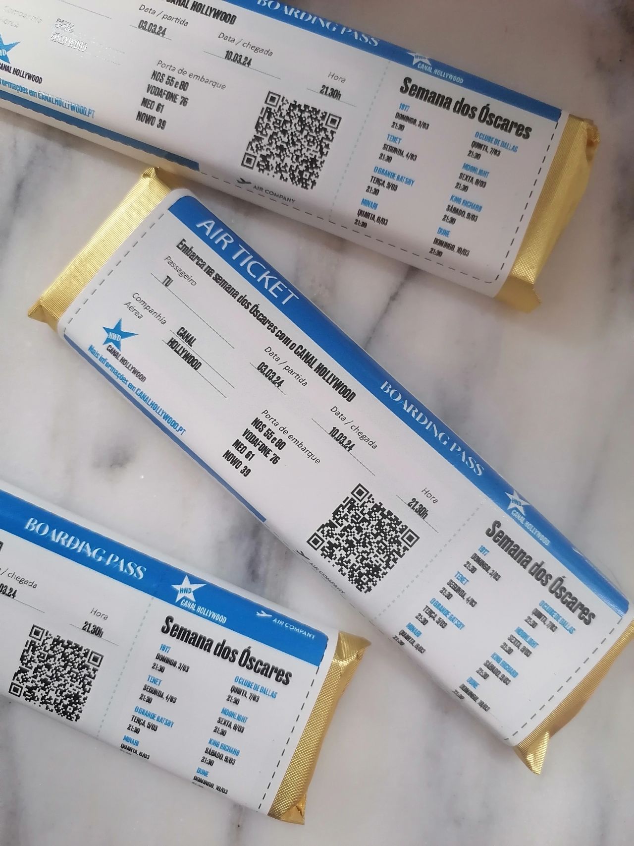 Barras de chocolate com rótulos que parecem bilhetes de avião numa superfície de mármore