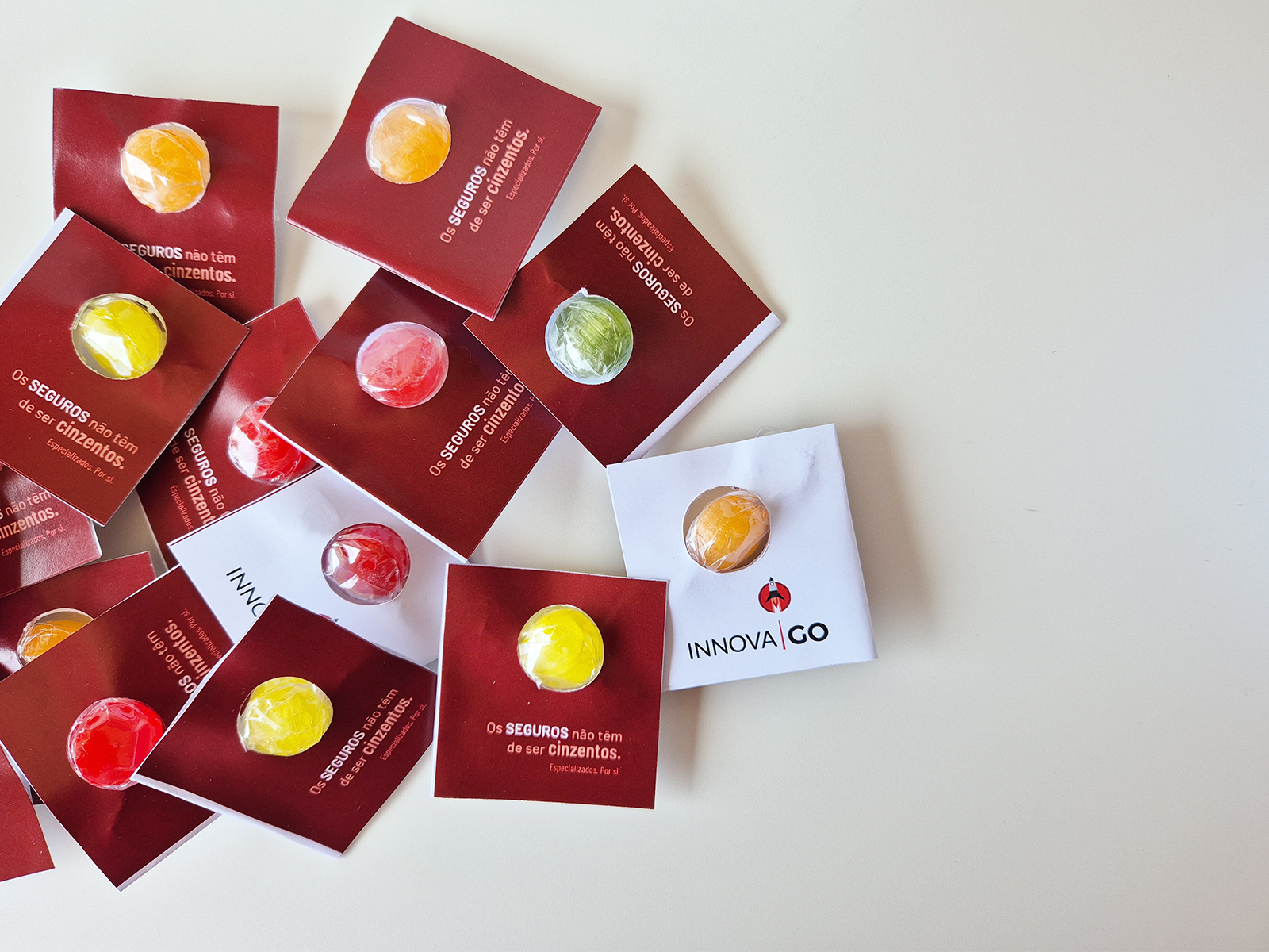 Pastilhas coloridas em embalagens de cartão vermelho e branco