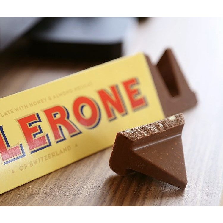 Chocolate Toblerone triangular com embalagem amarela e letras vermelhas e azuis