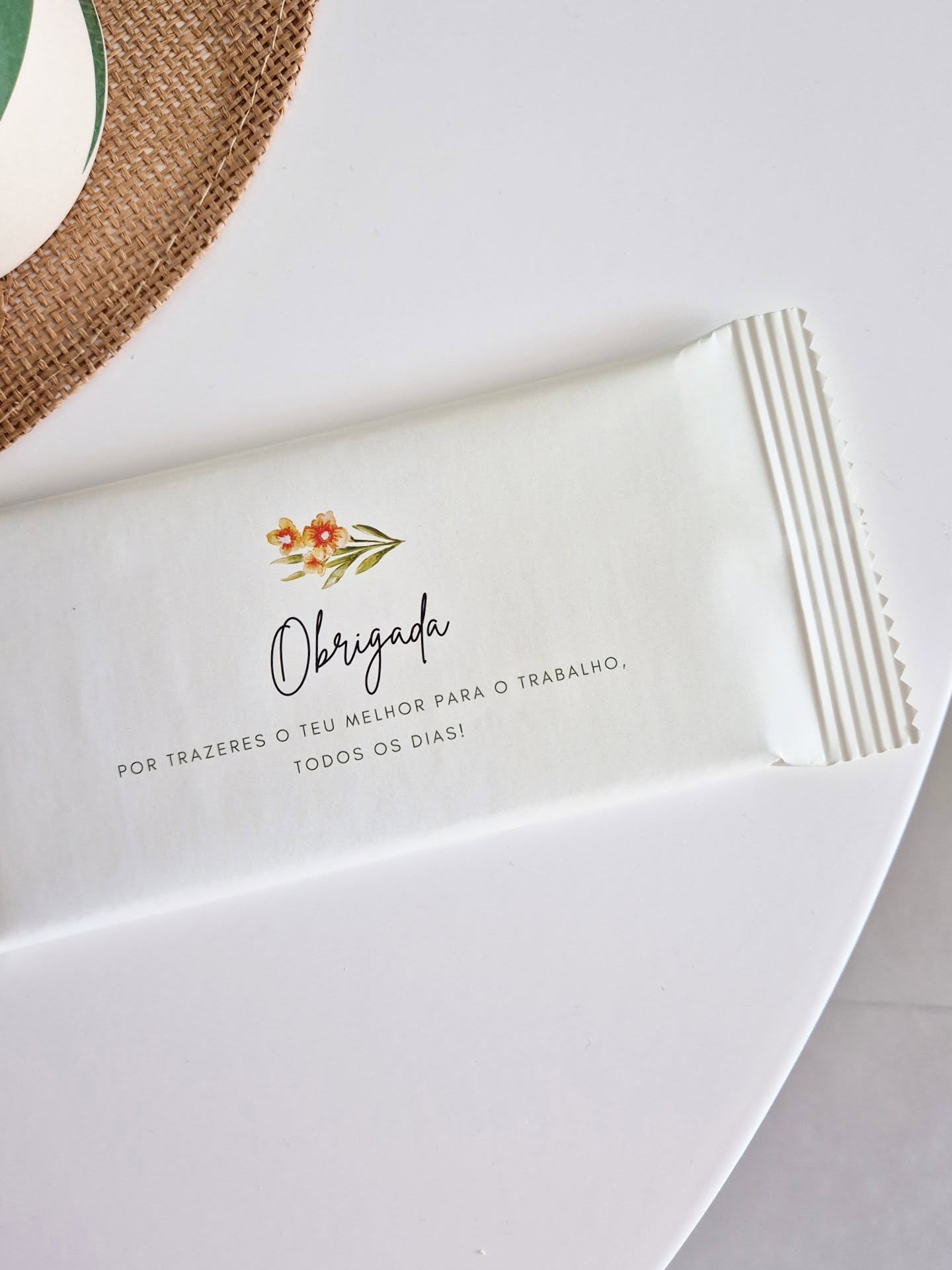 Embalagem branca com texto de agradecimento e desenho floral