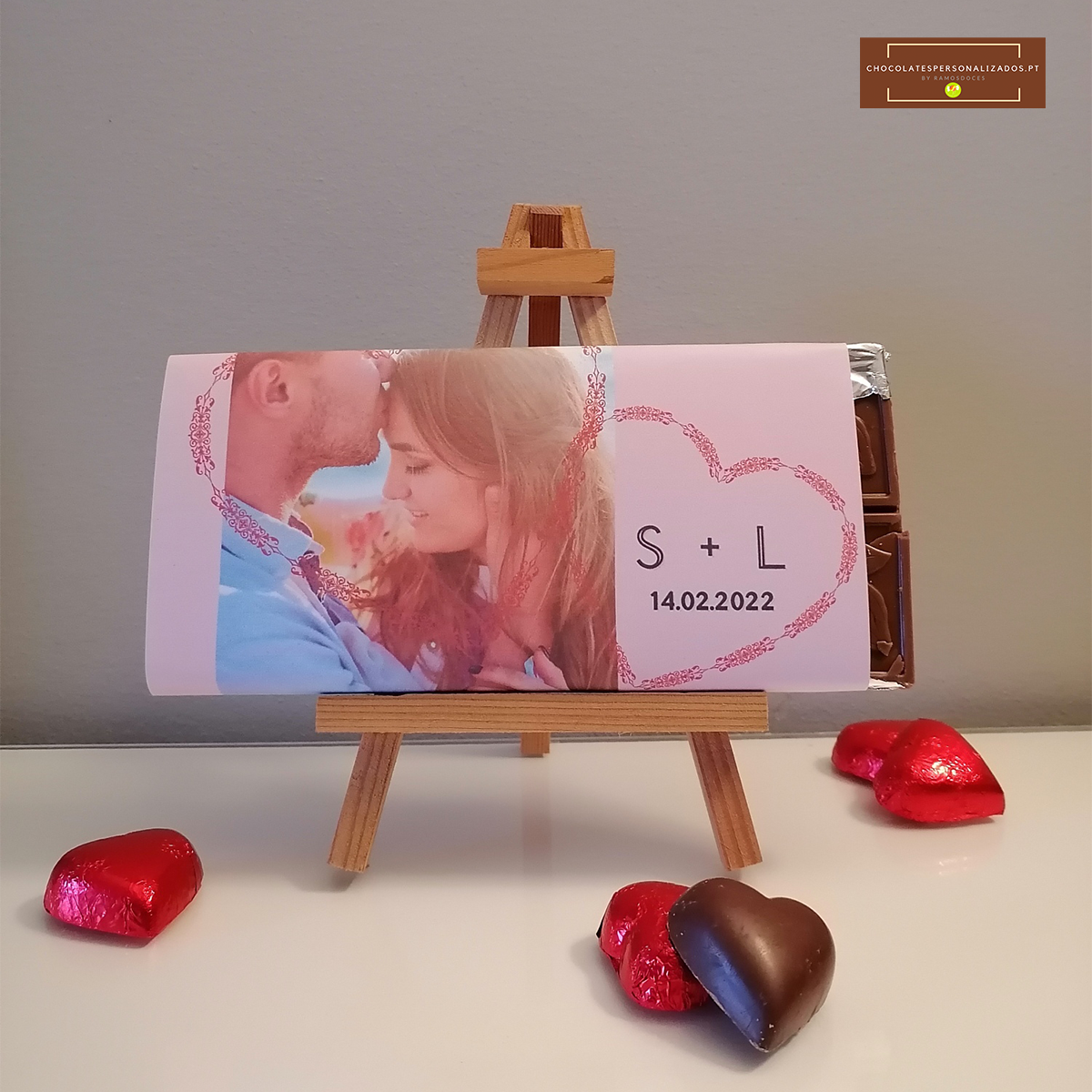 Barra de chocolate personalizada com foto de casal e data, num pequeno cavalete, com bombons em forma de coração ao redor