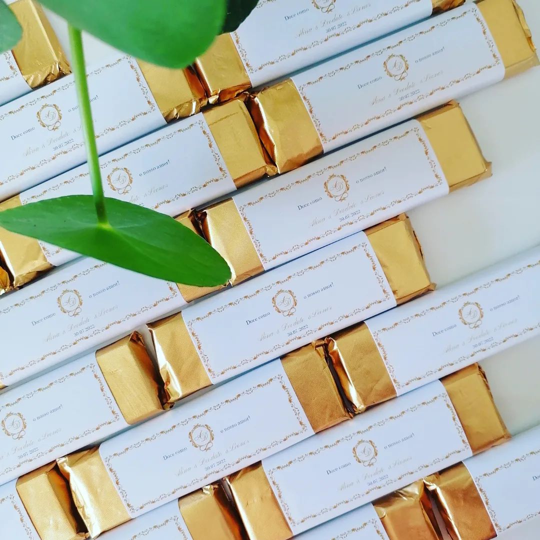 Barras de chocolate embaladas em papel branco com detalhes dourados e dourado metálico