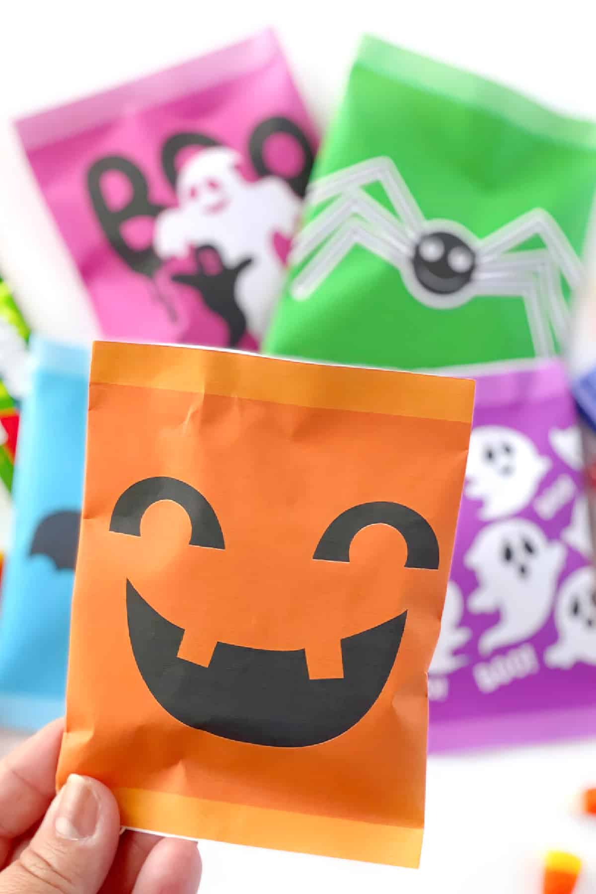 Pacote laranja com rosto de abóbora sorridente, outros pacotes de Halloween ao fundo