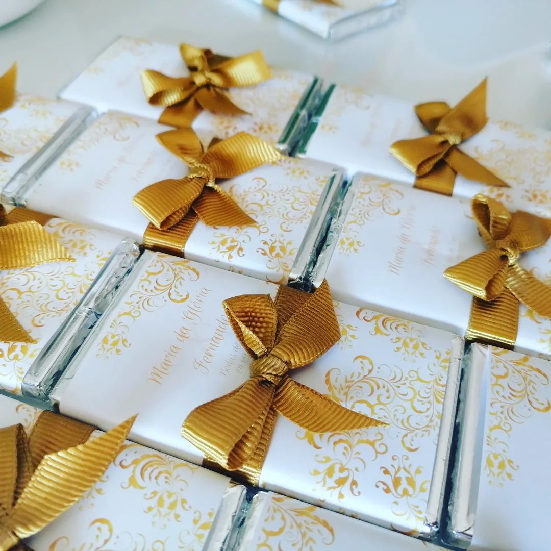 Chocolates embrulhados com papel branco e laço dourado