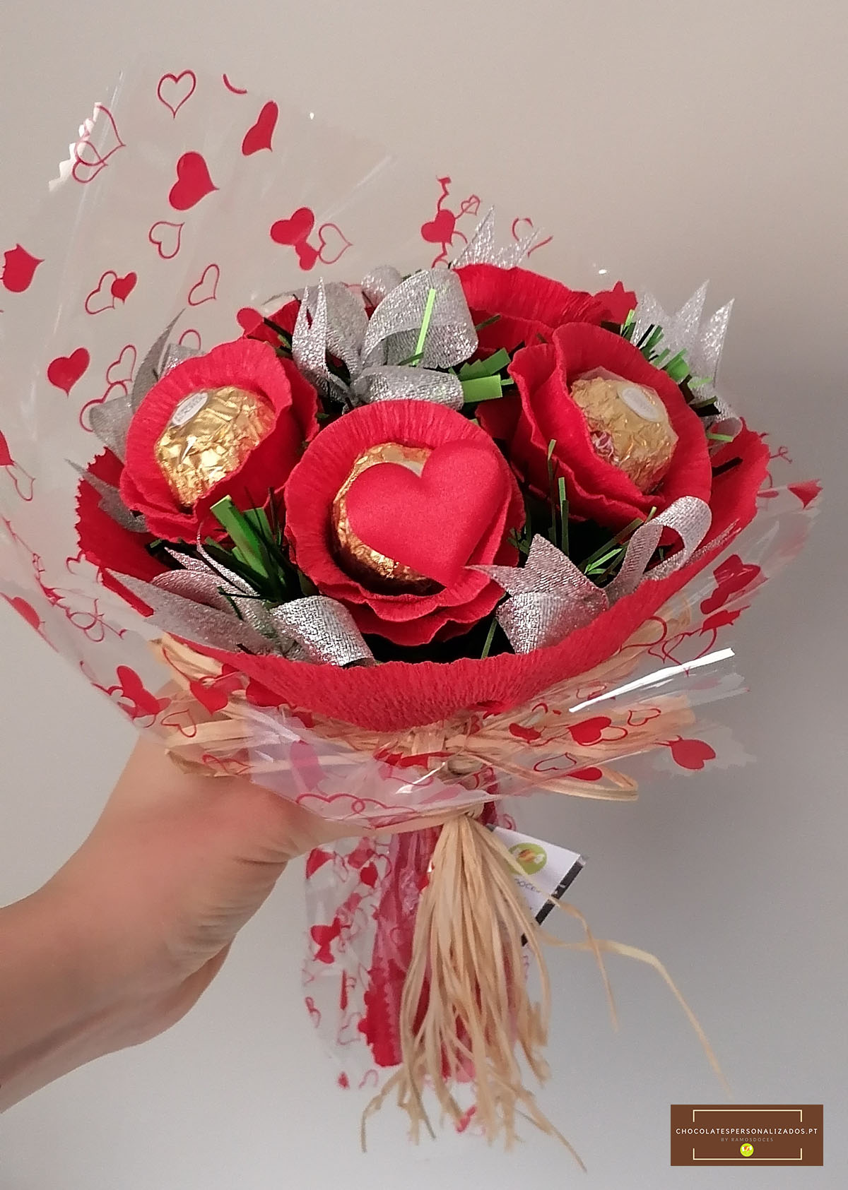 Bouquet decorativo com flores vermelhas e bombons dourados