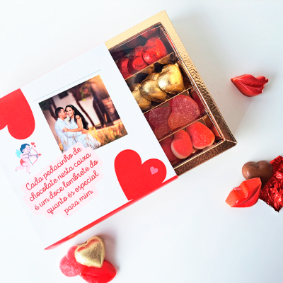 Caixa de chocolates variados em forma de coração e beijo, embalados e ao lado da caixa