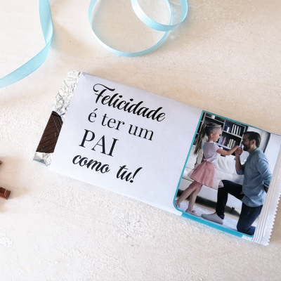 Barra de chocolate com embrulho personalizado para pai, fita azul e cataventos coloridos no fundo