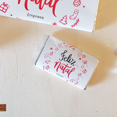 Barra de chocolate embrulhada com tema de Natal e texto FELIZ Natal.