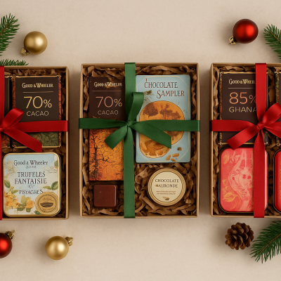 Três caixas de presente com barras de chocolate Good & Well e outros chocolates decoradas para Natal