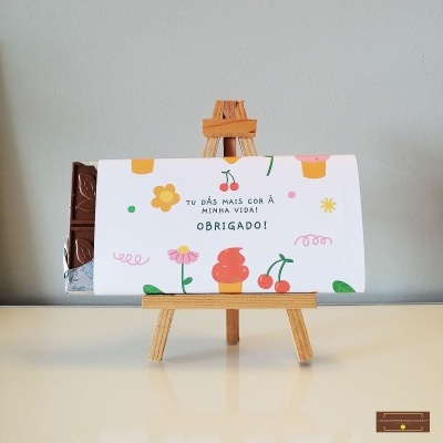 barra de chocolate embrulhada com papel branco colorido e cavalete de madeira
