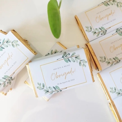 Barras de chocolate com embalagem branca decorada com folhas verdes e texto de agradecimento em dourado