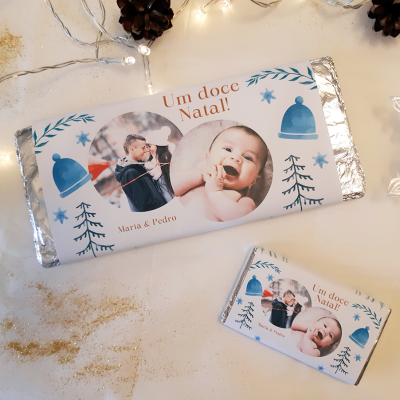 Barras de chocolate com rótulo personalizado de Natal com fotos e texto em embalagem de alumínio sobre mesa decorada.