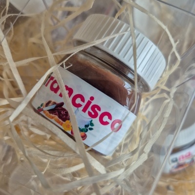 Frasco pequeno com creme marrom e rótulo 'Francisco' em embalagem transparente com palha