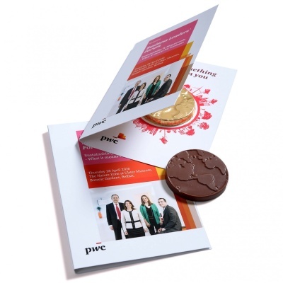 Dois chocolates redondos sobre folhetos promocionais da pwc