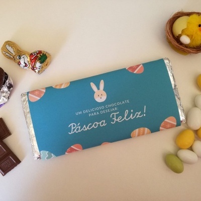 Barra de chocolate embrulhada azul com orelhas de coelho e ovos de Páscoa