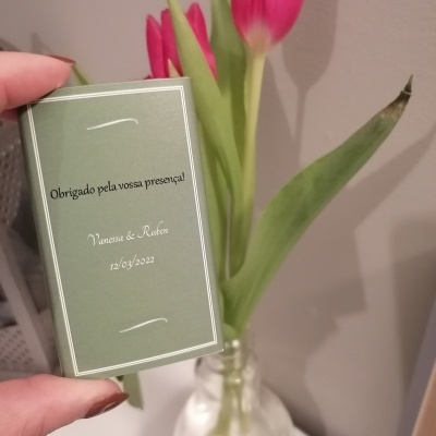 Embalagem verde com texto de agradecimento e vaso de vidro com tulipas rosas e folhas verdes