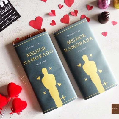 Dois tabletes de chocolate MELHOR NAMORADO com decorações de corações e bombons em fundo branco