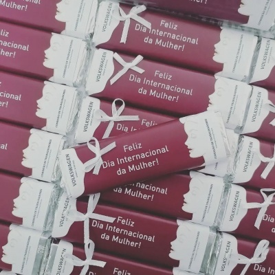 Barras de chocolate com embalagem cor de vinho e texto comemorativo da Dia Internacional da Mulher