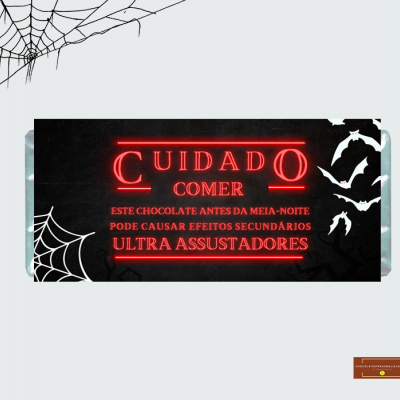 Embalagem preta de chocolate com texto vermelho e decoração de aranhas e morcegos