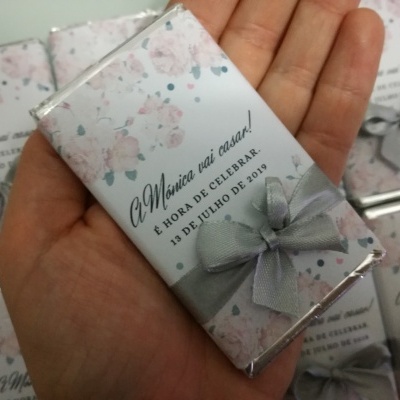 Chocolate embrulhado em papel floral com texto sobre casamento e laço cinzento
