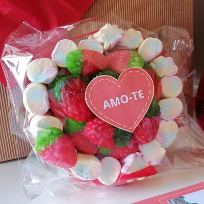 Doce em forma de morangos vermelhos e verdes com coração vermelho com texto 'AMO-TE', envolto em marshmallows e plástico transparente