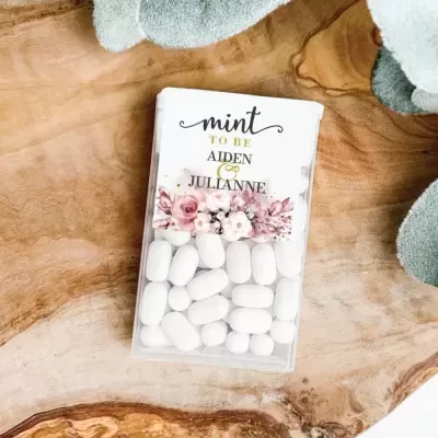 Embalagem de pastilhas brancas com etiqueta floral e texto decorativo