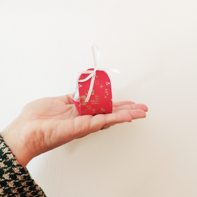 Um delicioso trabalho com Bombons para a Perfumes & Companhia 😍 Pequena caixa vermelha decorada com fita branca em mão feminina